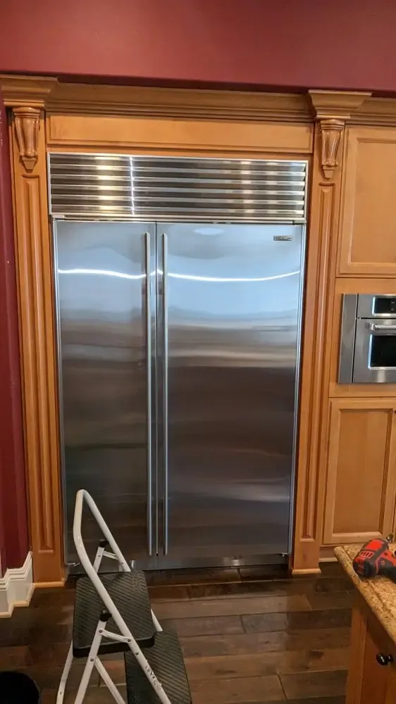 Sub-Zero built-in side-by-side refrigerator in custom cherry cabinetry before a service visit